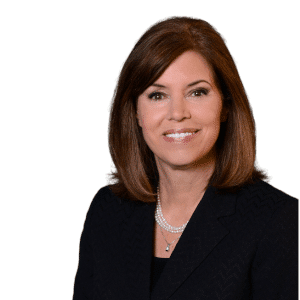Portrait of a smiling woman in a black blazer against a white background
