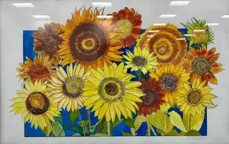 Bright sunflower mural in yellow, orange, and brown on a blue background in a bright indoor space