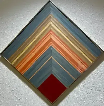 Abstract diamond-shaped wall art with layered blue, orange, tan, and red geometric stripes